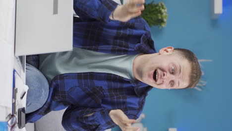 Vertical-video-of-Home-office-worker-man-looking-at-camera-clapping-and-getting-excited.